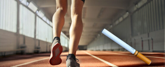 legs of a runner on a track with a picture of an e-cigarette at the bottom right side